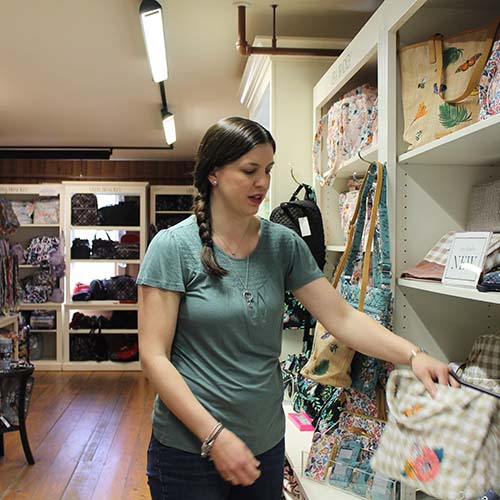 Woman standing while looking at Vera Bradley Bags